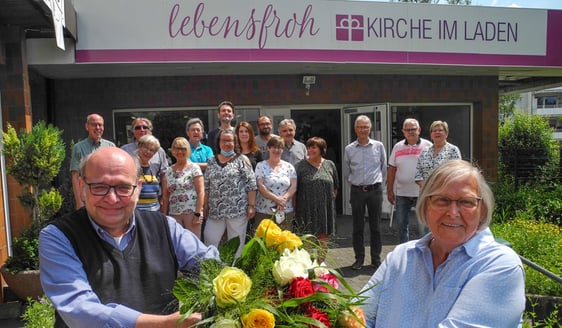 Wolfgang Dröpper (links) bedankte sich im Lebensfroh-Begegnungszentrum symbolisch mit bunten Rosen bei der Attendorner Tafel (Foto: Raith)